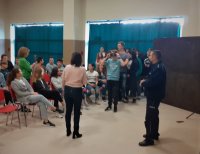 Policjant prowadzi prelekcję dla młodzieży w szkole.
