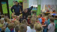Policjanci rozmawiają z przedszkolakami.