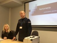 Naczelnik wydziału prewencji wita się z gośćmi spotkania w bielskiej komendzie.