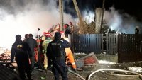 Policjanci i strażacy pracują na miejscu wybuchu i zawalenia się budynku.