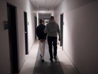 Policjant kryminalny prowadzi zatrzymanego.