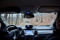 Policjanci jadą radiowozem. Widok z wnętrza pojazdu.