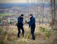 Policjanci przekazują sobie lornetkę. W tle panorama Jaworza i Bielska-Białej.