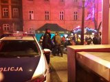 Policyjny radiowóz i policjant na świątecznym jarmarku.