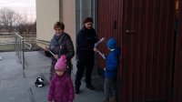 Policjantka rozdaje odblaski osobom wychodzącym z kościoła.