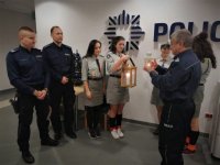 Harcerze przekazują policjantom Betlejemskie Światło Pokoju