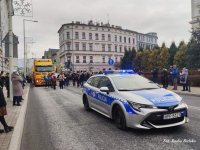 Policyjny radiowóz jedzie na czele świątecznego korowodu.