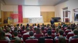 Policjant prowadzi prelekcję z młodzieżą.
