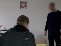 Policjant rozmawia z zatrzymanym.