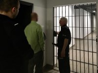 Policjanci doprowadzają do celi nietrzeźwego kierującego.