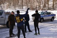Policjanci i strażnik leśny rozmawiają z turystami na szlaku.