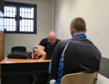 Policjant przesłuchuje podejrzanego o posiadanie narkotyków.