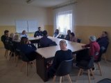 Policjant prowadzi spotkanie z podopiecznymi schroniska dla bezdomnych.