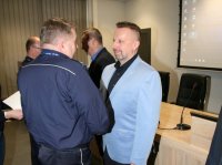 Komendant miejski składa gratulację policjantowi w ubiorze cywilnym.