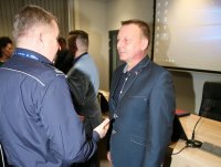 Komendant miejski składa gratulację policjantowi w ubiorze cywilnym.