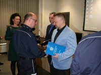 Zastępca komendanta miejskiego składa gratulację policjantowi w ubiorze cywilnym.