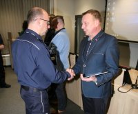 Zastępca komendanta miejskiego składa gratulację policjantowi w ubiorze cywilnym.