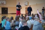 Policjanci prowadzą prelekcję z dziećmi na sali gimnastycznej