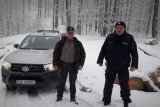 Policjant i strażnik leśny stoją na leśnej drodze.