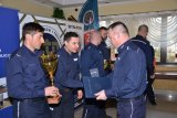Policjant odbiera dyplom w zawodach narciarskich.