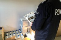 Policjant czyta opis na opakowaniu kombinezonu ochronnego.