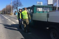 Policjant z ruchu drogowego i żołnierz WOT kontrolują pojazd.