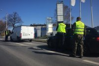 Policjant z ruchu drogowego i żołnierz WOT kontrolują pojazd.