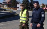 Policjant i żołnierz Wojsk Obrony Terytorialnej idą razem z patrolu pieszym.