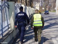 Policjant i żołnierz Wojsk Obrony Terytorialnej idą razem z patrolu pieszym.