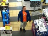 Wizerunek poszukiwanego mężczyzny podejrzewanego o kradzież. Kadr z monitoringu. Mężczyzna idzie przez halę sprzedażową sklepu z rtv i agd.