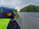 Policjant ruchu drogowego mierzy prędkość przy użyciu ręcznego radaru.