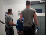 Nieumundurowani Policjanci trzymają zatrzymanego nieletniego