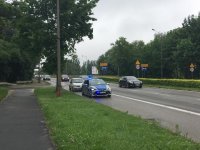 Widok na ulicę, przy której stoi radiowóz policyjny i kontrolowany pojazd