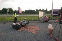 Policjant ruchu drogowego idzie obok przewróconego motocykla.