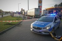 Na pierwszym planie policyjny radiowóz, w tle miejsce zdarzenia drogowego.