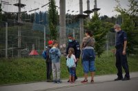 Policjanci rozmawiają z kobietą i trójką małych dzieci w rejonie wyciągu krzesełkowego.