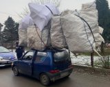 Policjanci kontrolują Fiata Seicento, który ma nadmierny bagaż na dachu