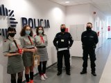 Policjanci i harcerze stoją na korytarzu komisariatu podczas przekazywania Betlejemskiego światła pokoju.