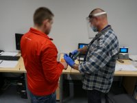 Technik Kryminalistyki pobiera odciski palców od zatrzymanego mężczyzny