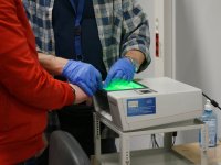 Technik Kryminalistyki pobiera odciski palców od zatrzymanego mężczyzny