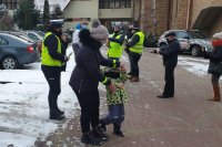 Policjanci i redaktorzy radiowi rozdają odblaski.