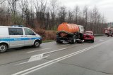 Miejsce wypadku drogowego, na zdjęciu osobowa mazda, ciężarówka oraz samochód policyjny i wóz strażacki. Pochmurny dzień,