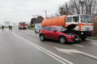 Miejsce wypadku drogowego, na zdjęciu osobowa mazda, ciężarówka oraz samochód policyjny i wóz strażacki. Pochmurny dzień,