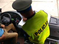 Policjant z ruchu drogowego kontroluje kierowcę siedzące w autokarze