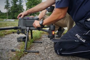 Policjanci wymieniają baterie w służbowym dronie.