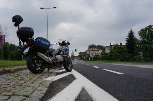 Policyjny motocykl stoi przed sygnalizacją świetlną.