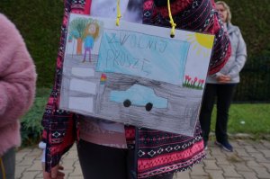 Dziecko trzyma w rękach rysunek o tematyce ruchu drogowego