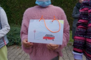 Dziecko trzyma w rękach rysunek o tematyce ruchu drogowego
