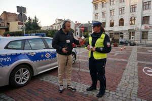 Policjantka udziela wywiadu dziennikarzowi z Radia Bielsko. Obok zaparkowany jest radiowóz