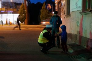 Policjantka przekazuje dziecku odblask.